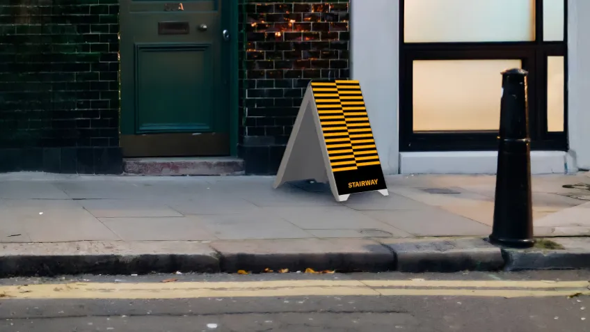 Obojstranné reklamné áčko z PVC s potlačou umiestnené na chodníku pred prevádzkou