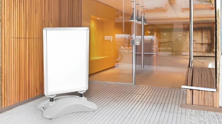 Reklamné áčko so zaťaženou základňou umiestnené pri vstupe do budovy