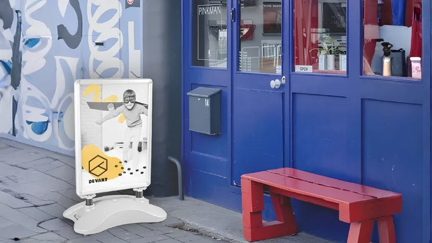 Vonkajšie reklamné áčko so zaťaženou základňou a potlačou pred vstupom do prevádzky