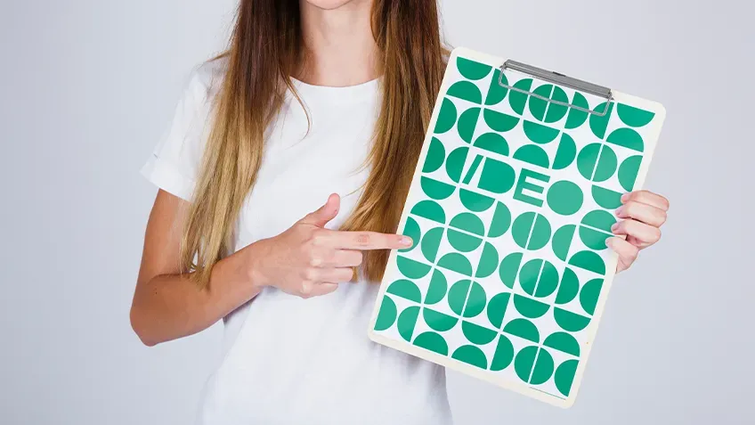 Personalizovaný clipboard A4 so zelenou potlačou držaný v rukách